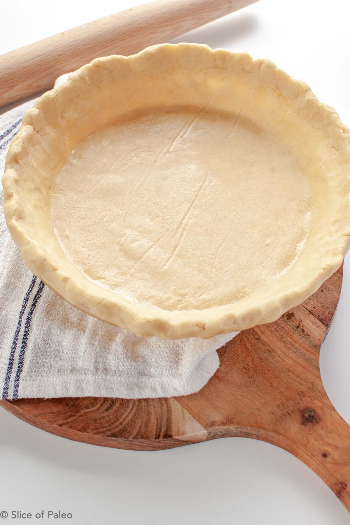Paleo pie crust dough in a pie pan with egg wash