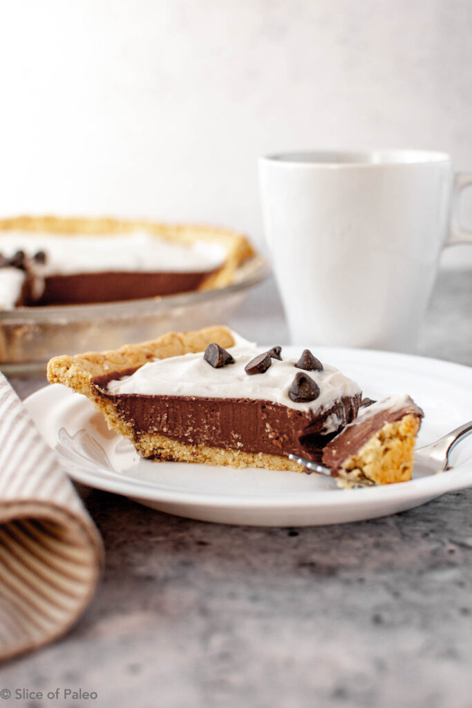 Paleo Chocolate Cream Pie served on a white plate with coffee