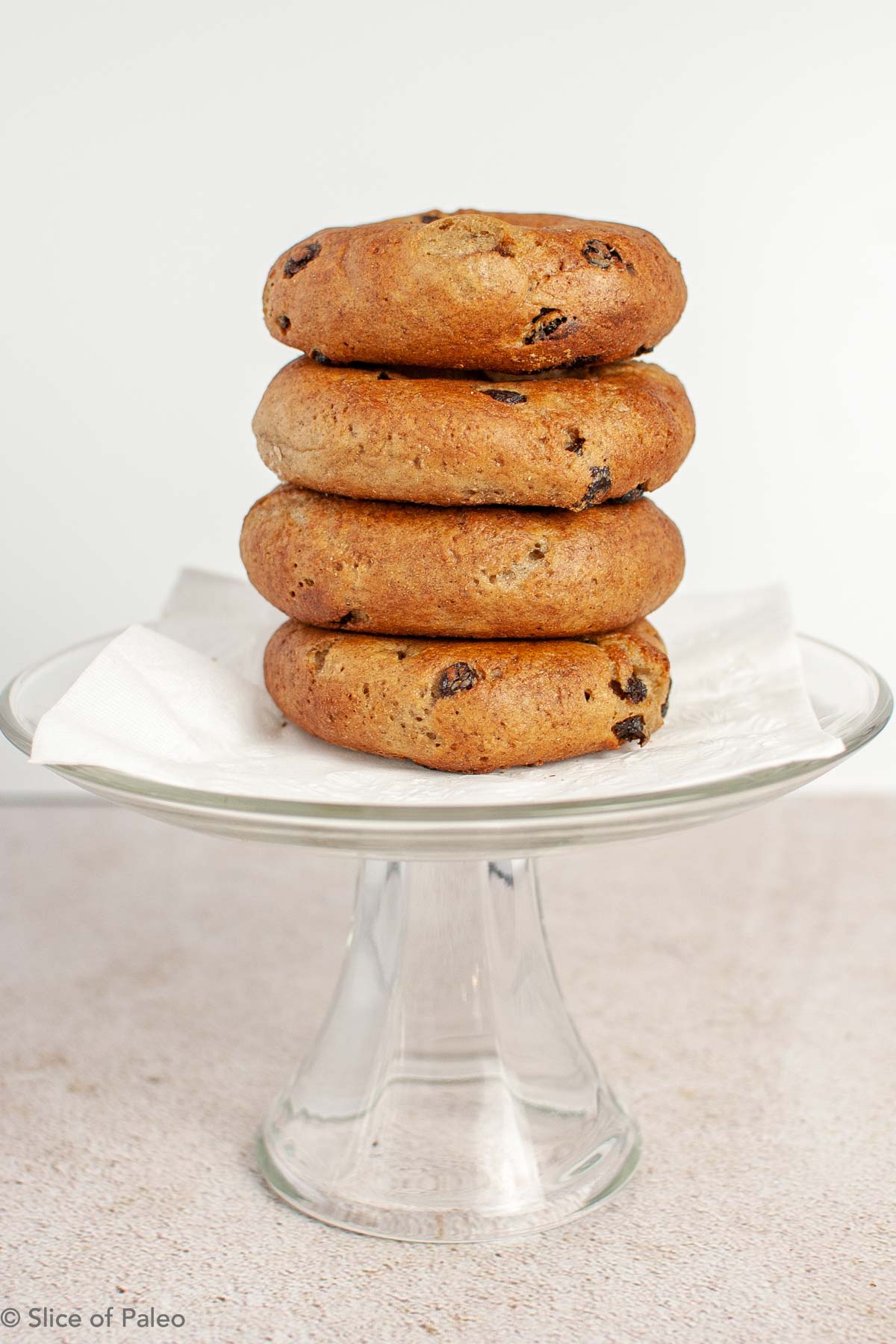 Paleo Cinnamon Raisin Bagels stacked on a cake stand