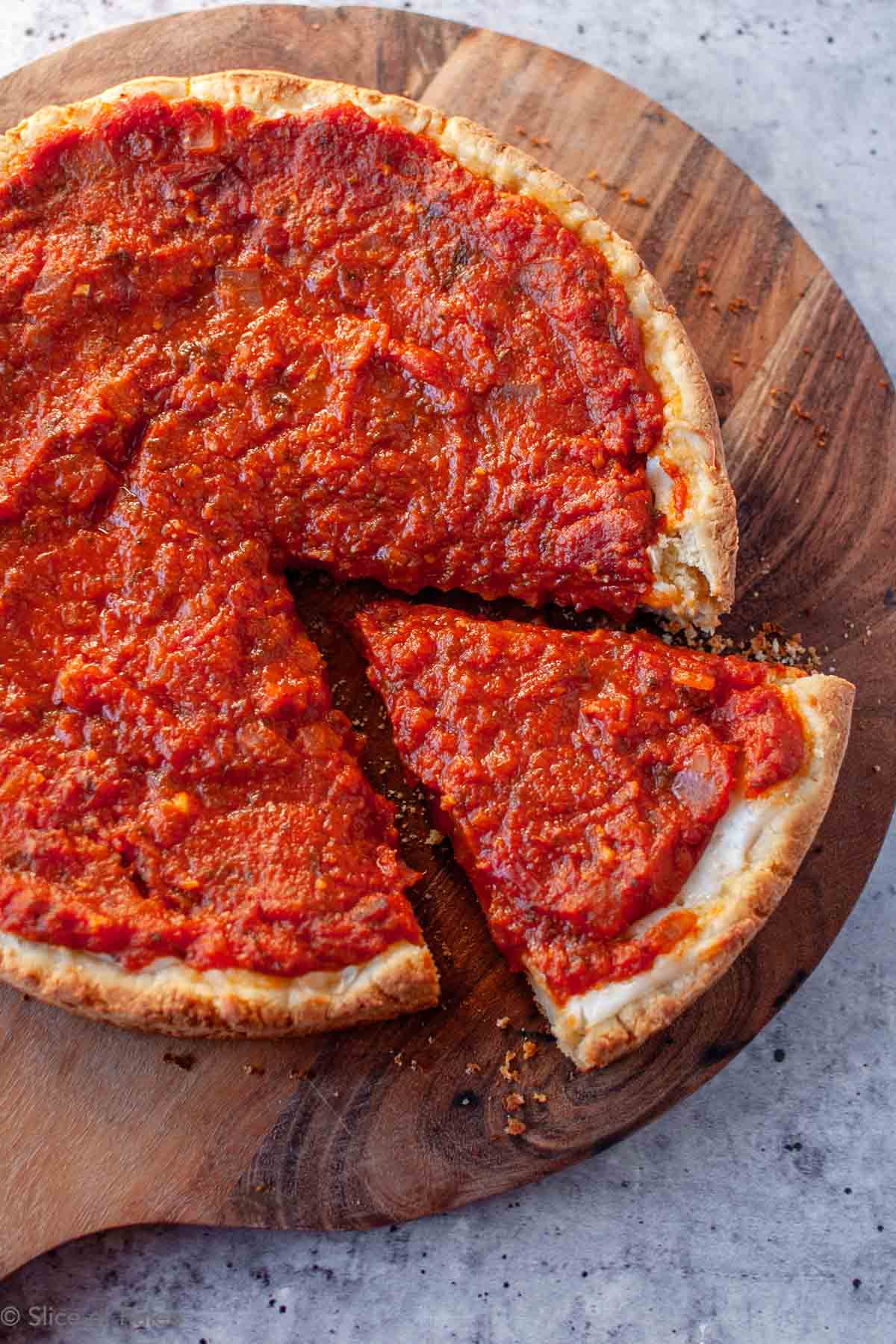 Paleo Chicago Style Deep Dish Pizza baked with one slice cut from the whole pizza.