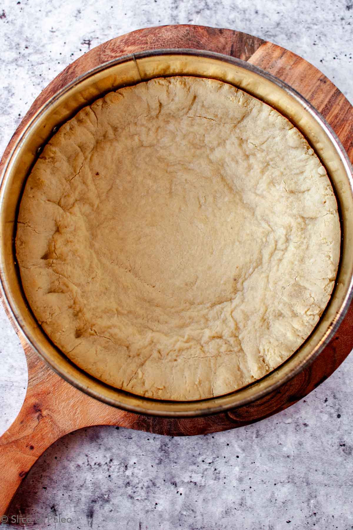 Paleo Chicago Style Deep Dish Pizza dough partially baked in a springform cake pan.