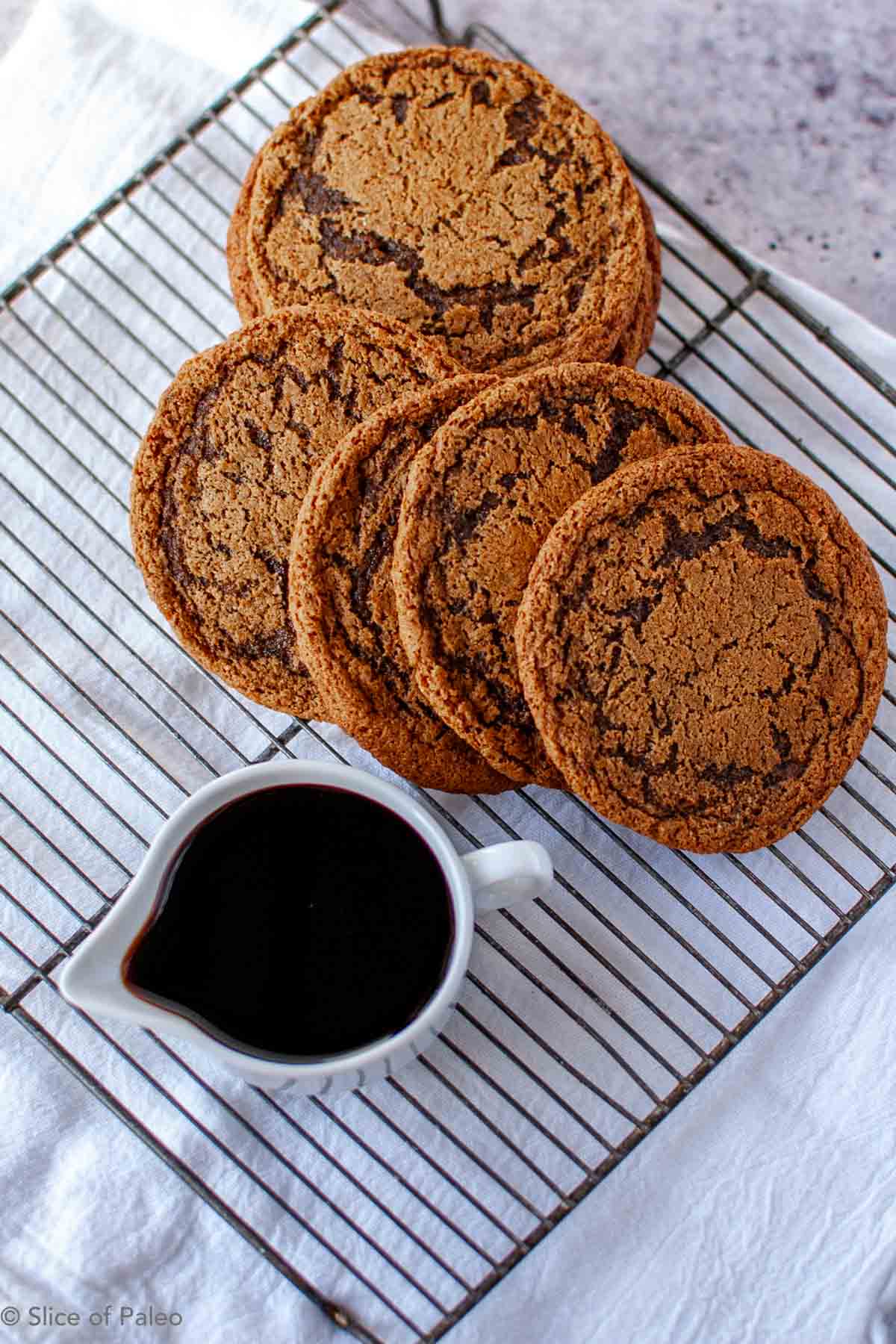 Paleo Molasses cookies layered on a cooling rack.